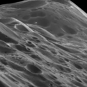 Image 8IapetusPhoto credit: Cassini orbiterA close-up of 10&nbsp;km (6.2&nbsp;mi) high mountains within the equatorial ridge on Saturn's moon Iapetus, photographed by the Cassini orbiter. Above the middle of the image can be seen a place where an impact has exposed the bright ice beneath the dark overlying material. The image was taken on September 10, 2007, with the Cassini spacecraft narrow-angle camera at a distance of approximately 3,870&nbsp;km (2,400&nbsp;mi) from Iapetus.More selected pictures
