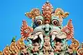 Sriramgam Jambukeshwara Kirtimukha top of gopuram with ring-necked parakeet