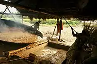 A man tilting a large metal disk to put out the contents
