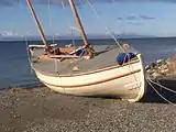 The replica of James Caird to the Strait of Magellan, with in the background the Tierra del Fuego.