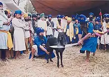 A Kirpan being used for Jhatka by Rajput community for normal eating; Sikhs in preparing Jhatka meat for the Sikh Sangat in Langar