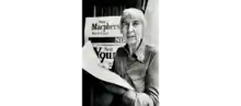 Kay Macpherson standing in front of a poster that states "Kay Macpherson York East NDP"