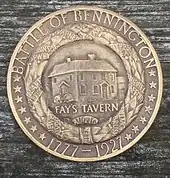 A bronze medal, bearing the legends, "BATTLE OF BENNINGTON" and "1777-1927" and 14 stars.  This surrounds a wreath with ribbons with the names of battle participants such as "ALLEN". Within the wreath is a building, and the inscription "FAY'S TAVERN".