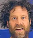 Neal Tehama County headshot, straight on, with wild eyes, wild hair, and wild beard.
