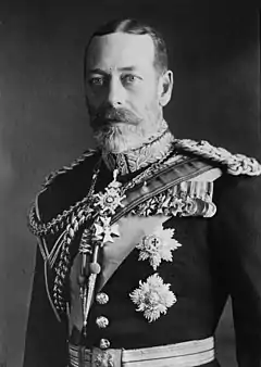 George V is pale-eyed, grey-bearded, of slim build and wearing a uniform and medals.