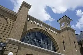 A railway station with a brick façade and a clock on one side