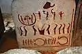 One of the slabs of stone shows people (eight in long robes)