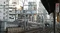 View from the platform of Kanda Station, October 2009. A bridge pylon is being built to carry a viaduct of the future Ueno–Tokyo Line. A ramp structure can be seen in the background.