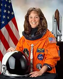 A smiling Nowak in her orange space suit