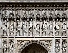 Statues of ten people in niches over a door.