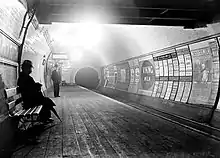 Eastbound platform shortly after opening in 1900 – sign above man on bench says "(Marb)le Arch"