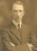 A sepia photo of a man in a suit with a tie.