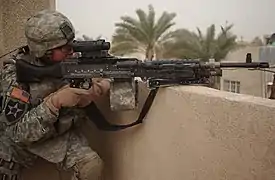 A U.S. 2nd Infantry Division soldier pulls security on top of a roof using an M240B with an attached M145 (ARD) and AN/PEQ-2