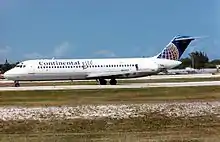 A white, narrow-body aircraft on an airport taxiway, with the words "Continental Lite" painted on the side