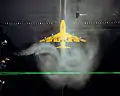 A Boeing 747 model has just passed through a stationary sheet of smoke, which is showing its trailing vortices, at the Vortex Facility at the Langley Research Center.