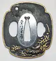 A mokko shakudo tsuba front side, decorated with a pheasant and plants, by Kikugawa Nanpo (late Edo period)