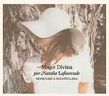 A brunette woman is wearing a white blouse and a white hat that covers her most of her face. The words "Mujer Divina" and "Homenaje a Agustín Lara" are placed beneath her.