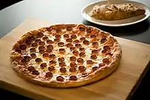 A cooked pizza with pepperoni, showing distinct curling and darkening of color