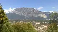 The rounded hillside of a mountain overlooking a valley.