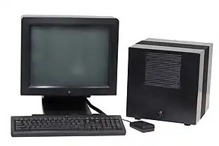 A black NeXTstation computer and a black NeXTcube workstation; the latter is housed in a cube-shaped magnesium enclosure