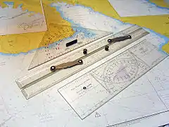 A "Cras navigation plotter" double-protractor, in foreground, named after his inventor Jean Cras.