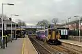 A Northern Rail Class 156 waits at the station.