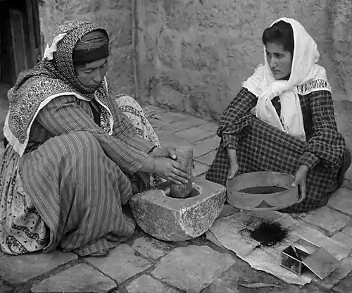 Image 141905 Stereoscope. Original caption reads: The native mode of grinding coffee, Palestine.Credit:American Colony Jerusalem (edited by Durova)