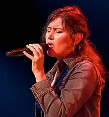 Cole singing into a microphone