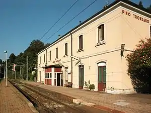 Two-story stuccoed building with gabled roof