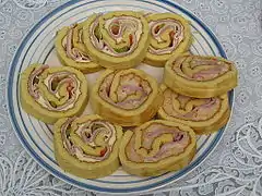 Sliced Savory Argentine pionono, with Ham, cheese, Salsa golf and vegetables
