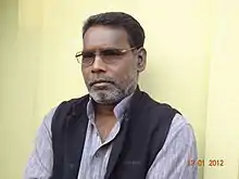 Tarai standing in front of a yellow wall