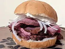 A pitbeef sandwich with tiger sauce and onions