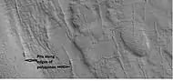 Close-up of pits forming along the edges of polygons in patterned ground, as seen by HiRISE under the HiWish program.  Resolution is about 30&nbsp;cm, so one could see a kitchen table if it were in the picture.