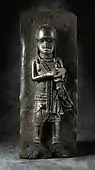 Plaque that probably represents a musician; 17th century; bronze; 48.26&nbsp;cm (19 in.) x 18.42 (7.mw-parser-output .frac{white-space:nowrap}.mw-parser-output .frac .num,.mw-parser-output .frac .den{font-size:80%;line-height:0;vertical-align:super}.mw-parser-output .frac .den{vertical-align:sub}.mw-parser-output .sr-only{border:0;clip:rect(0,0,0,0);clip-path:polygon(0px 0px,0px 0px,0px 0px);height:1px;margin:-1px;overflow:hidden;padding:0;position:absolute;width:1px}1⁄4 in.) x 8.89&nbsp;cm (3.mw-parser-output .frac{white-space:nowrap}.mw-parser-output .frac .num,.mw-parser-output .frac .den{font-size:80%;line-height:0;vertical-align:super}.mw-parser-output .frac .den{vertical-align:sub}.mw-parser-output .sr-only{border:0;clip:rect(0,0,0,0);clip-path:polygon(0px 0px,0px 0px,0px 0px);height:1px;margin:-1px;overflow:hidden;padding:0;position:absolute;width:1px}1⁄2 in.), irregular; Los Angeles County Museum of Art (USA)