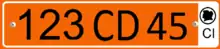 Plate with a single row of black alphanumeric characters on an orange background, and a white bar on the right side containing the black letters CI at the bottom, and a black silhouette of the Ivory Coast inside a black circle at the top.