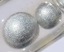 Potassium pearls under paraffin oil. Size of the largest pearl is 0.5&nbsp;cm.