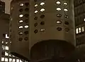 Detail of the tower facade at night, with oval windows illuminated