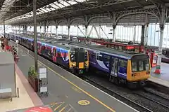 Two trains – one modern, and one from the eighties – in a Victorian railway station.