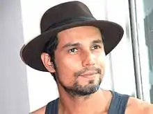 Hooda wearing a hat looking into the camera