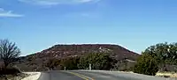 Round Mountain, a butte located 6&nbsp;mi (9.7&nbsp;km) to the northwest of Comanche, Texas, where Robert T. Hill first observed Lower Cretaceous fossils and strata. (.mw-parser-output .geo-default,.mw-parser-output .geo-dms,.mw-parser-output .geo-dec{display:inline}.mw-parser-output .geo-nondefault,.mw-parser-output .geo-multi-punct{display:none}.mw-parser-output .longitude,.mw-parser-output .latitude{white-space:nowrap}31°55′30″N 98°42′07″W﻿ / ﻿31.925°N 98.702°W﻿ / 31.925; -98.702) (30 December 2008)