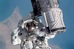 STS104-315-013 (July 12–24, 2001) --- Holding onto the end effector of the Canadarm on the Space Shuttle Atlantis, astronaut Michael L. Gernhardt, STS-104 mission specialist, participates in one of three STS-104 space walks.