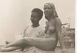 A young Sagini standing beside his statue of a nude woman