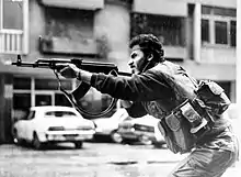 Shiite Muslim AMAL militiaman firing his AK-47 assault rifle during skirmishes with Druze irregulars on Corniche-al-Mazraa road in West Beirut, Lebanon