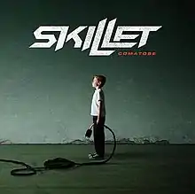 A photo of a boy holding a plug in a tunnel with "Skillet - Comatose" above the boy.