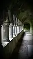 A dark barrel-vaulted corridor with an arcade on the left