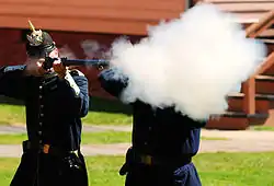 Reenactor firing a Springfield Model 1873 breech-loading rifle at Fort Mackinac in 2008.