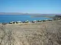 A campsite with chalets at the water's edge. Note the dry conditions (conducive to bush fires) in the wintertime.
