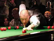 Davis leaning over a table for a shot