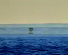 In this mirage, at least three separate images of a boat are visible. The real one at the bottom and the uppermost one are in the upright position, whereas the one in the middle is inverted