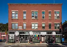 Taft Brothers Block, prominently located in the town center at the corner of Mendon and Main Streets. It is a three-story brick structure with modest Late Victorian stylistic embellishments.